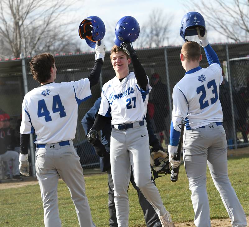 Newman's Brendan Tunink (center) celebrates with Kyle Wolfe (44) and Jaeson Johns (23) after hitting a 2-run homer against the Cardinals during a Wednesday, April 5 game in Forreston.