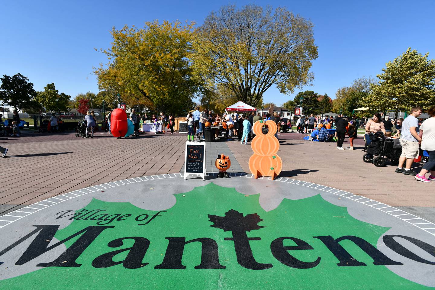 Costumed attendees visit the Fall Fair on the Square in Manteno, hosted by the Manteno Chamber of Commerce, LaMore Realty and Whitmore Ace Manteno in 2022. Various local merchants offered games and prizes and free pumpkin carving was provided by Whitmore Ace Hardware for contribution to the annual "Great Pumpkin" display at the Square on Second.