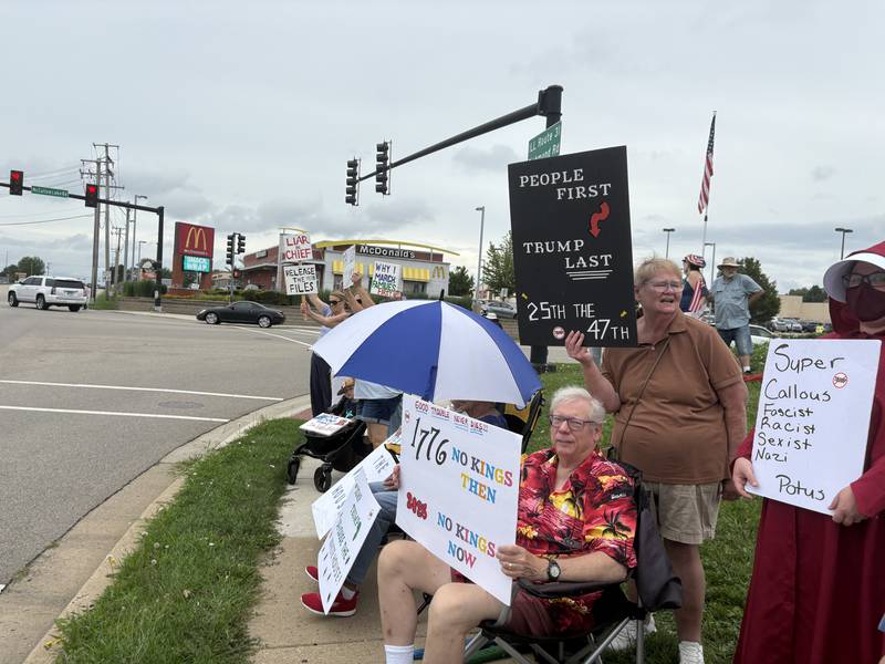 Protestors hold signs during a protest against President Trump in McHenry July 26, 2025.