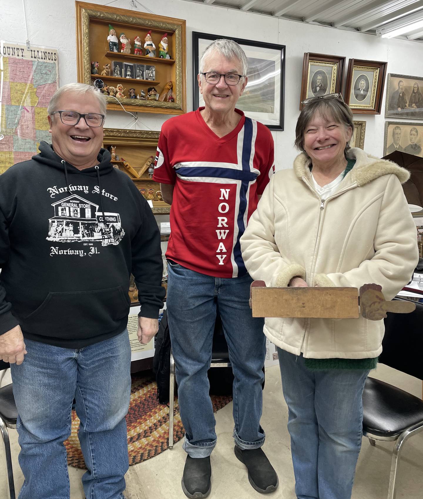 Chuck and Sue Borchsenius stand on each side of Dave Johnson, Norsk Museum president, after the Borchsenius family donated the Norway Temperance Hall to the museum.