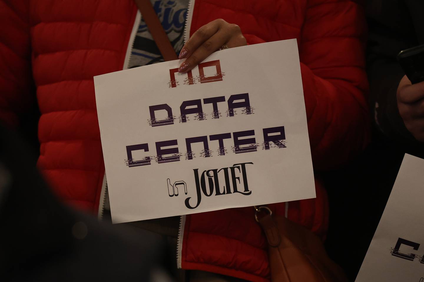 Residents holds signs against the proposed Data Center at the City of Joliet Plan Commission meeting on Thursday, March 5, 2026 in Joliet.