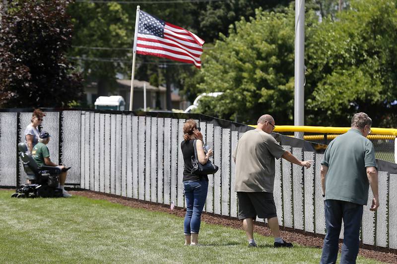 People visit the Vietnam Traveling Memorial Wall at the VFW Post 4600 in McHenry, on Friday, July 14, 2023.  The 3/5 scale wall will be at the post and open to the public until Sunday evening and will hold an opening  ceremony at 10 a.m. on Saturday.