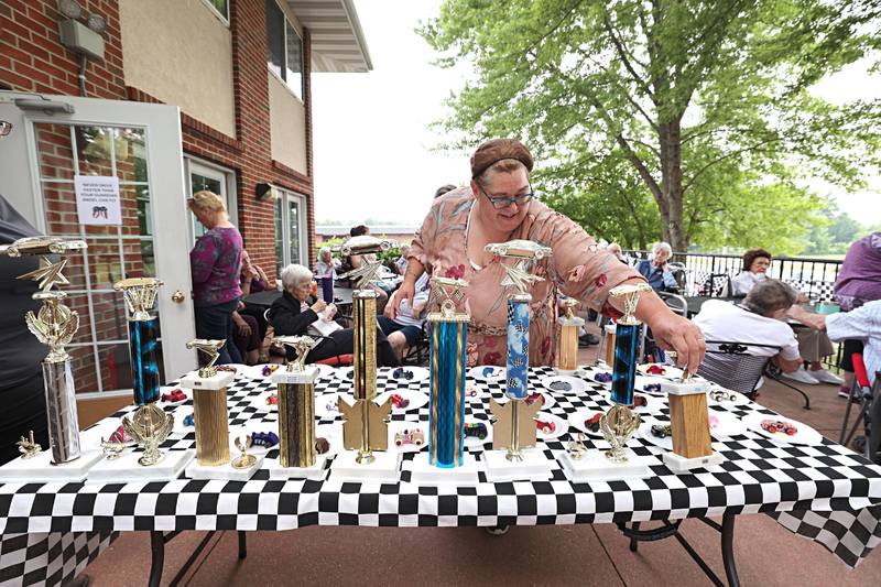 Amanda Wolfe, dietary manager, checks out the trophies given to the winners of the decorated cars during Franklin Grove Assisted Living’s car show Friday, June 23, 2023.