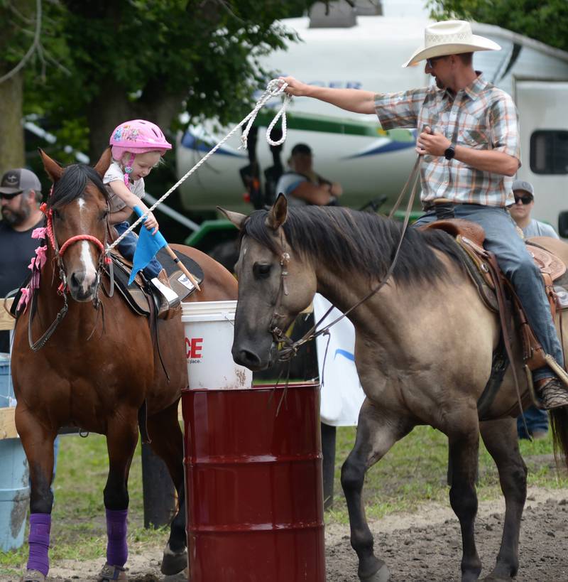 Savannah Chapman, 3, of Earlville, and her horse Sweet Pea, 20, along with her dad Brad and his horse Hank, 6, compete in the Flags Competition at the Rock River Trail & Horseman Association's Grand Opening Show on Saturday, July 20, 2024.