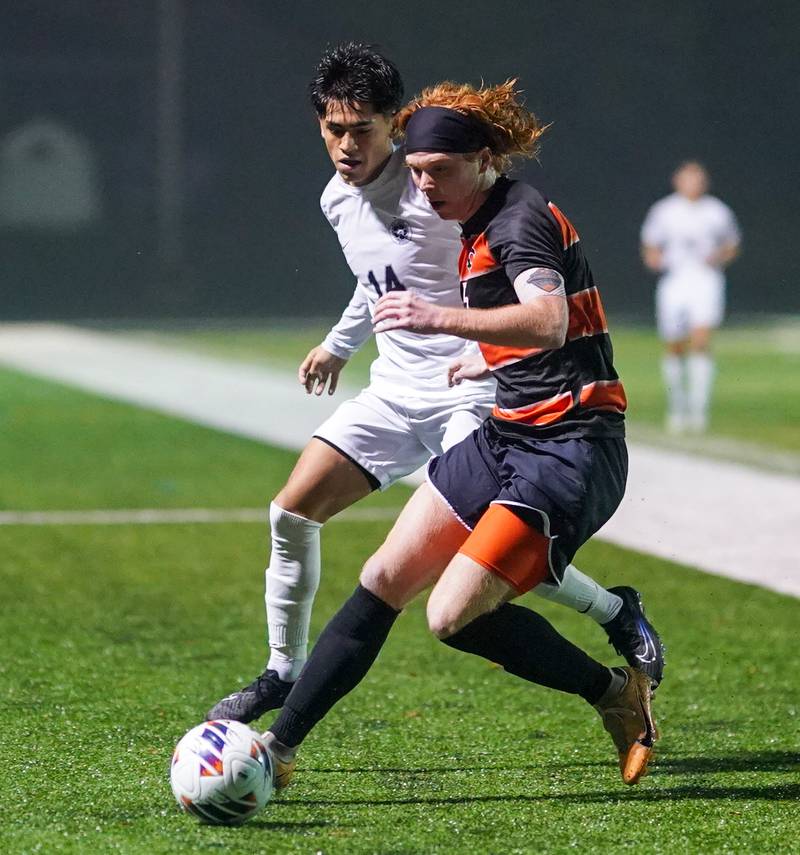 St. Charles East's Jake Walker (5) plays the ball against West Chicago's Aldo J. Alfaro (14) during a class 3A sectional semifinal soccer match at West Chicago High School on Wednesday, Oct. 25, 2023.