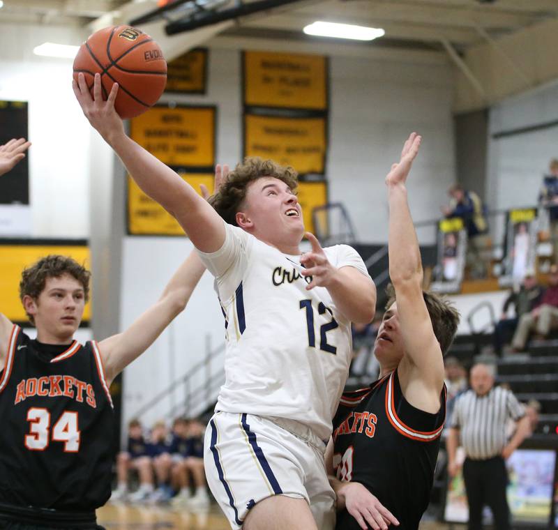 Marquette's Krew Bond runs between Roanoke-Benson's Kaden Harms and Jackson Beer to score on a layup during the Tri-County Conference Tournament on Wednesday, Jan. 25, 2023 at Putnam County High School.