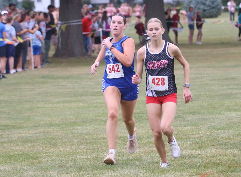 Princeton's Natalie Meyer runs with Amboy's Grace Althaus during the Gary Coates Invitational cross country meet on Saturday, Sept. 13, 2025 at Zearing Park in Princeton .