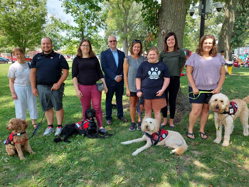 (From left) Ruth Ann Robertson, of United Way; Jake Burcenski with Gemma, of Woodland School; Elizabeth Palm with Luna, of United Way; Ben Hiltabrand, president of the United Way Board; Mary Lerette and Jacque of Northlawn with Piper; Courtney Levy, of the Streator Area Chamber of Commerce; and Karen Dye, of Kimes School pose for a photo Tuesday, Aug. 8, 2023, as the therapy dogs wear their new vests at City Park.