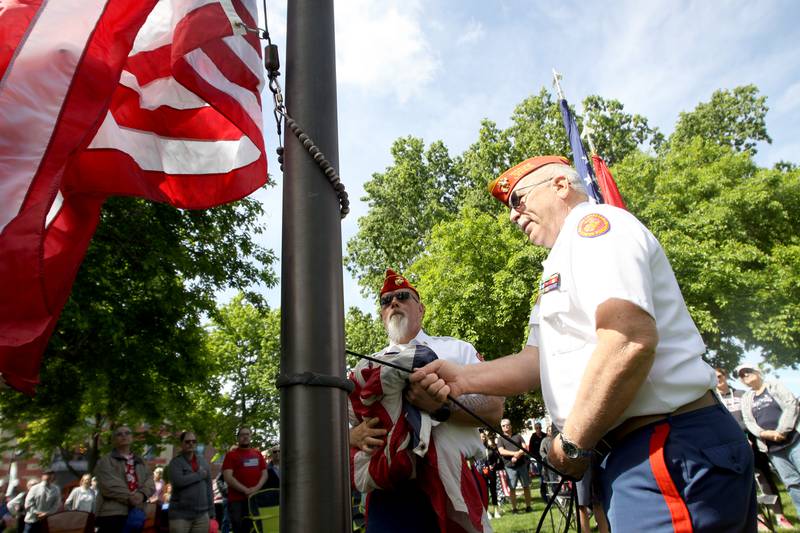 Service members hoist a new flag during a Memorial Day service in downtown Woodstock on Monday, May 26, 2025.