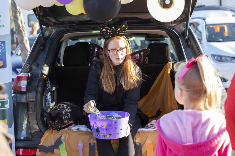 Georgia Brown of Sterling and her “side-cat” Binx hands out candy Wednesday, Oct. 26, 2022 at SPD’s trunk or treat. Brown and Binx were representing Sauk Valley Bank.