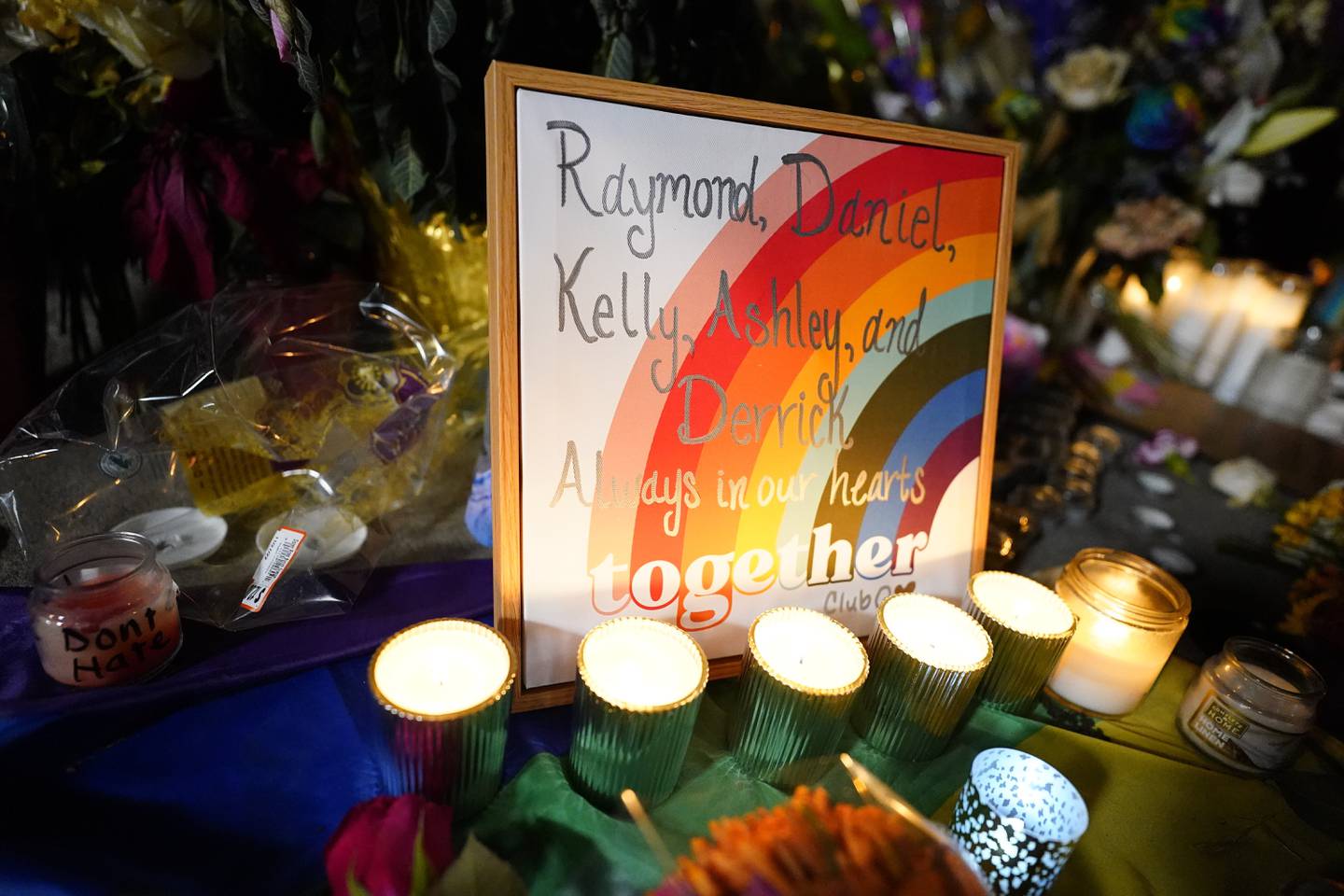 Names of the victims are shown on a rainbow during a candlelight vigil on a corner near the site of a weekend mass shooting at a gay bar, late Monday, Nov. 21, 2022, in Colorado Springs, Colo. (AP Photo/Jack Dempsey)