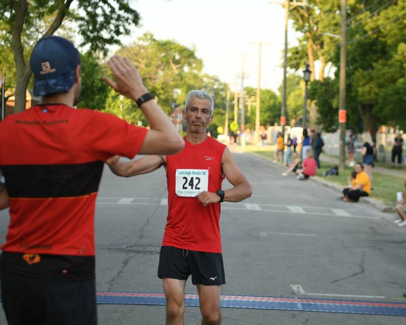 Krzysztof Waclawek,242, gets congratulated by Johannes Schulz after getting second over all during the Leadershop 5K event on Friday June 9 2023 held in La Grange.