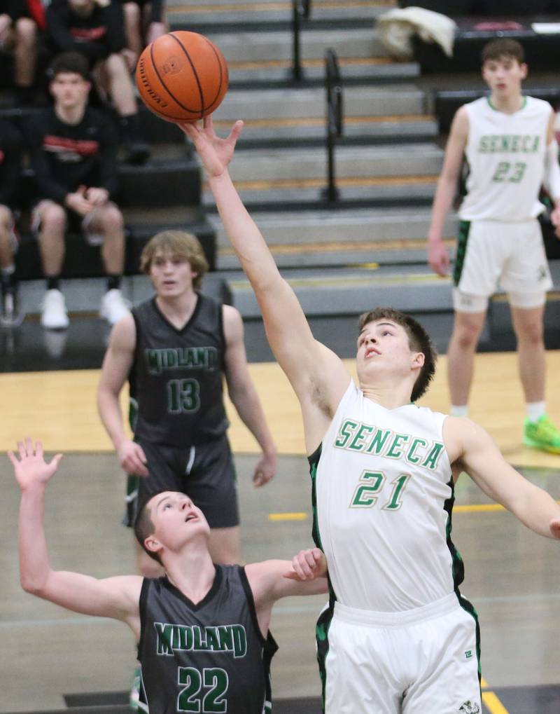 Seneca's Lane Provance grabs a rebound over Midland's Quin Gauwitz during the Tri-County Conference Tournament on Thursday, Jan. 25, 2024 at Putnam County High School.