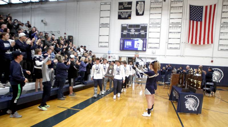 Players march into the main gym during a celebration of the IHSA Class 6A Champion Cary-Grove football team at the high school Sunday.