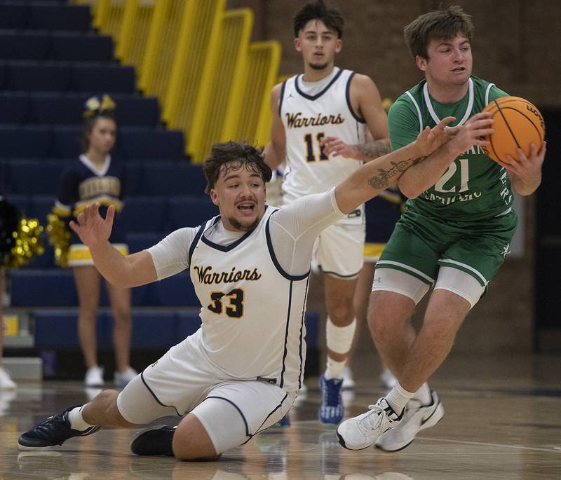 Sterling’s Maddux Osborn reaches for a ball handled by Alleman’s Robbie Wolfe Friday, Dec. 20, 2024, at Sterling High School.