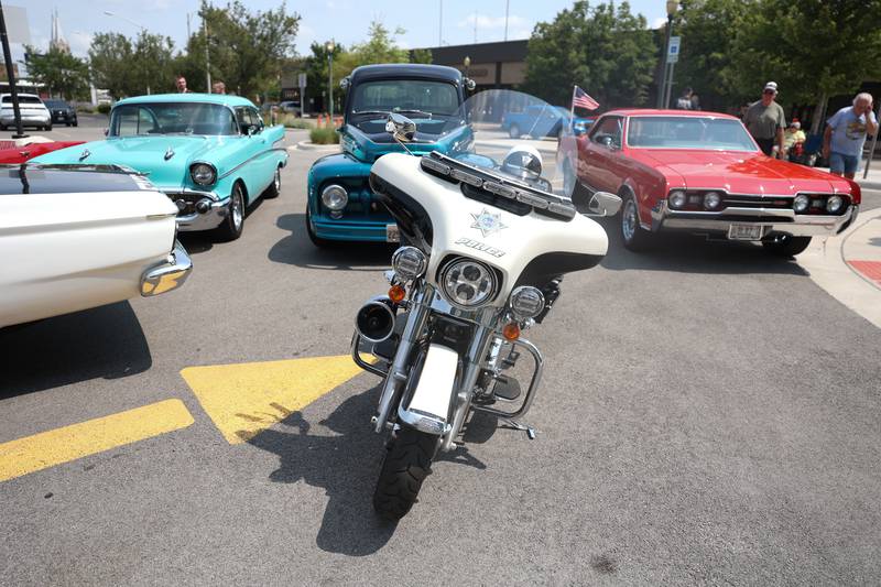 A Joliet police motorcycle sits in front of several vintage cars at the Speed Catches Up With You speed awareness campaign on Tuesday, July 23, 2024 in Joliet.