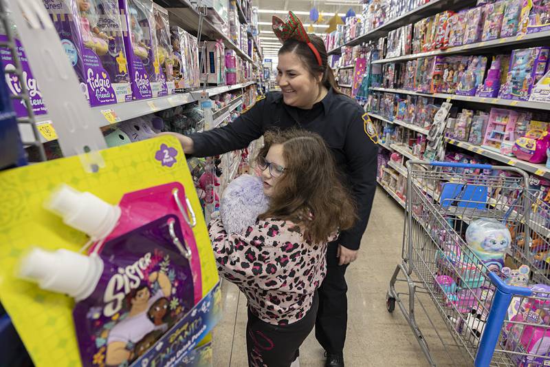 Layla Giordano, 7, shops with Sterling Police Detective Tabatha Justice Saturday, Dec. 10, 2022 at the Sterling Walmart for the annual Shop with a Cop.