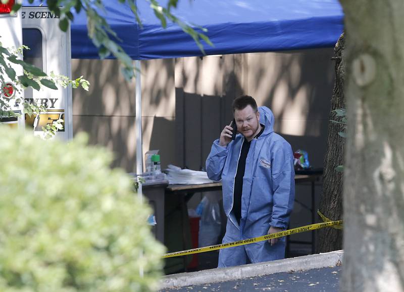An investigator talks on a phone in front of a home in 5800 block of Wild Plum Road in unincorporated Crystal Lake on Thursday, Aug. 10, 2023, as the McHenry County Sheriff's office continued to investigate the scene where four family members, including three females and a male “aggressor,” were killed Wednesday.