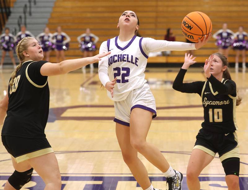 Rochelle's Gianna Olguin goes between Sycamore’s Sycamore's Camryn Knox (left) and Cortni Kruizenga Friday, Dec. 5, 2025, during their game at Rochelle High School.