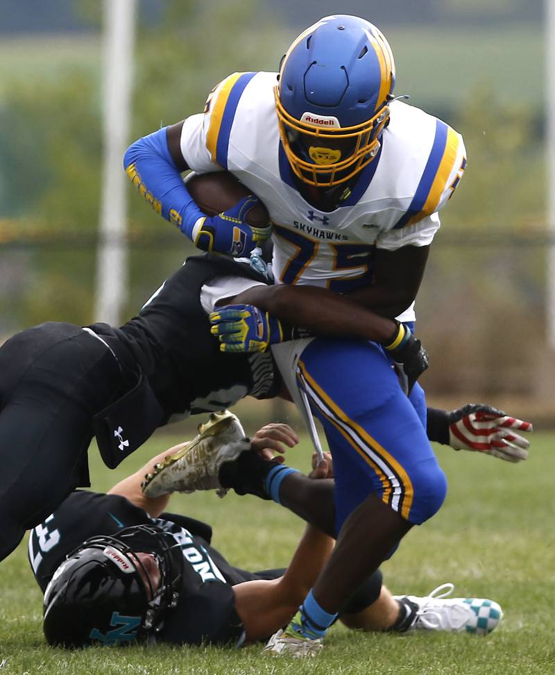 Johnsburg's Chiamaka Ameachi is tackled by Woodstock North's Maxwell Dennison and Kaden Combs during a Kishwaukee River Conference football game Saturday, Aug. 26, 2023, at Woodstock North High School.