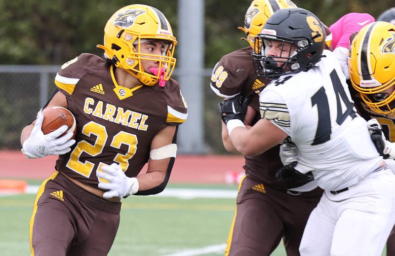 Carmel's Donovan Dey runs past Sycamore's Kiefer Tarnoki during their Class 5A second round playoff game Saturday, Nov. 5, 2022, at Carmel Catholic High School in Mundelein.