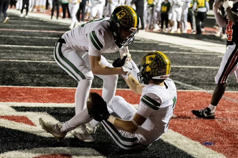 Fremd’s Carter MacDonald helps up Ben Riddle after Riddle scored a touchdown during an 8A varsity football playoff game against Bolingbrook at Bolingbrook on Nov. 15, 2025.