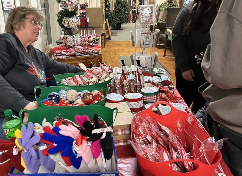 Mary Elliott of Stampin' Up! tends to a customer at Conover Square during Oregon's Candlelight Walk on Saturday, Nov. 30, 2024.