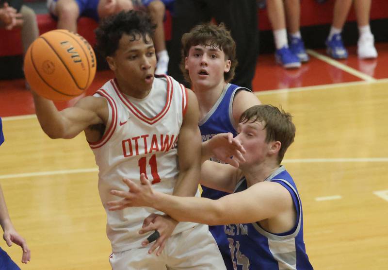 Ottawa's Hezekiah Joachim passes the ball off over Princeton defenders Stihl Brokaw and Ryan Jagers during the Dean Riley Shootin' The Rock Thanksgiving Tournament on Monday Nov. 24, 2025 in Kingman Gymnasium at Ottawa High School.