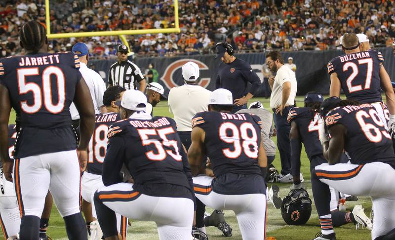 Members of the Chicago Bears take a knee after teammate defensive back Terell Smith, gets carted off the field from a knee injury against the Buffalo Bills on Sunday, Aug. 17, 2025 at Soldier Field in Chicago.