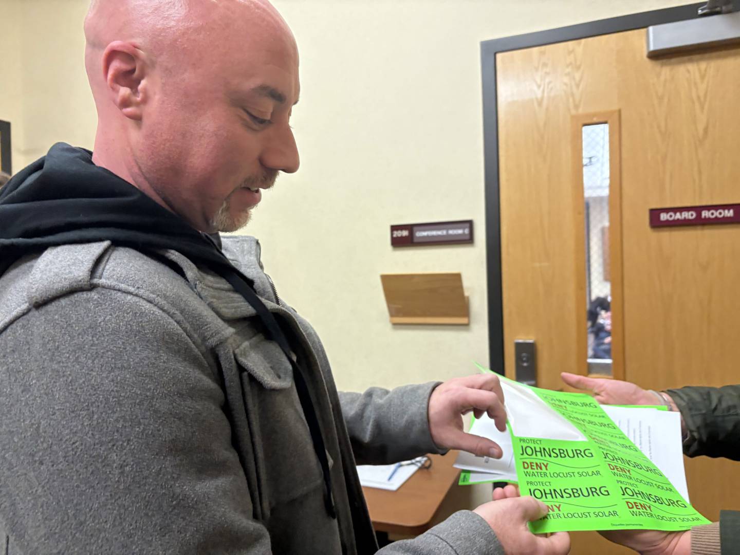 Jay Goldberg grabs a sticker before the McHenry County Board meeting Nov. 18, 2025.