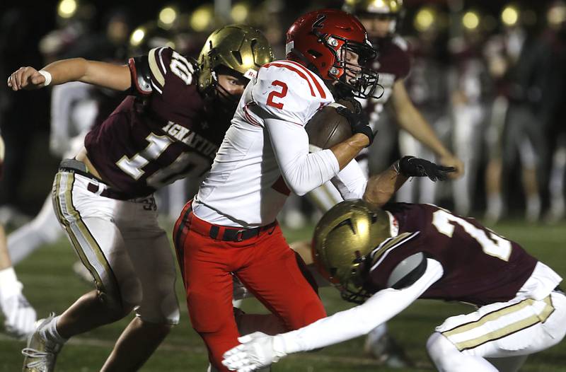 Huntley's Zack Garifo is tackled by St. Ignatius' Hayes Mueller, (left) and Liam Doyle as he returns a kickoff during a IHSA Class 8A second round playoff football game on Friday, Nov. 3, 2023, at St. Ignatius College Prep in Chicago.