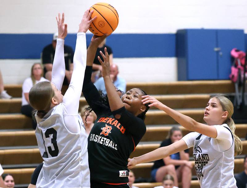 DeKalb’s Johnna Patrick goes to the basket between two Kaneland defenders Thursday, June 12, 2025, in the Geneva High School Varsity Summer League.