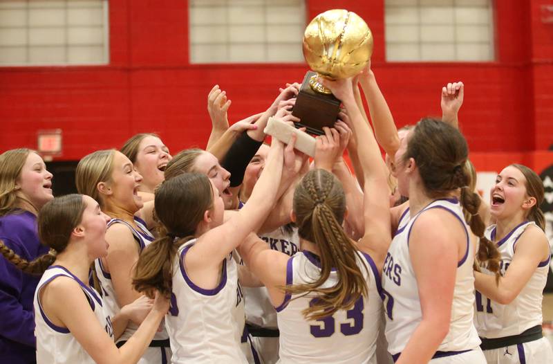 Members of the Serena Lady Huskers basketball team hoist the Little Ten Conference championship trophy after beating Hinckley-Big Rock on Friday, Jan. 24, 2025 at Earlville High School.