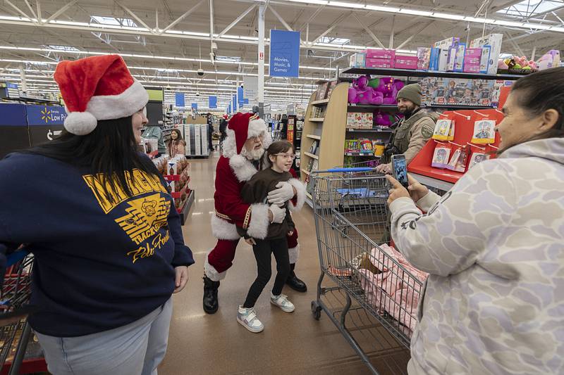 Santa has fun while taking a picture with a young shopper Saturday, Dec. 13, 2025, at Dixon’s Walmart. The annual Shop with a Cop was divided into two sessions on Saturday.