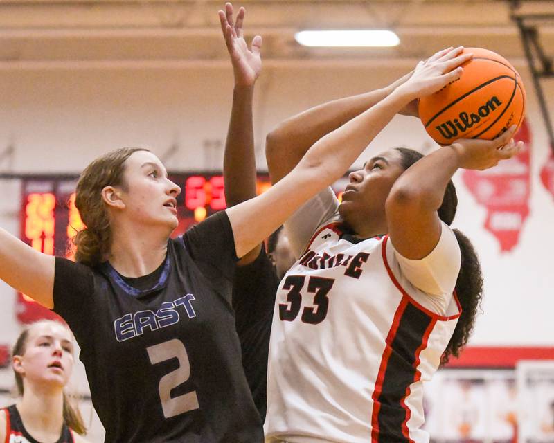 Oswego East's Annabelle Williams (2) blocks the shot of Yorkville's Claire Donelson (33) during the game on Thursday Dec. 18, 2025, held at Yorkville High School.