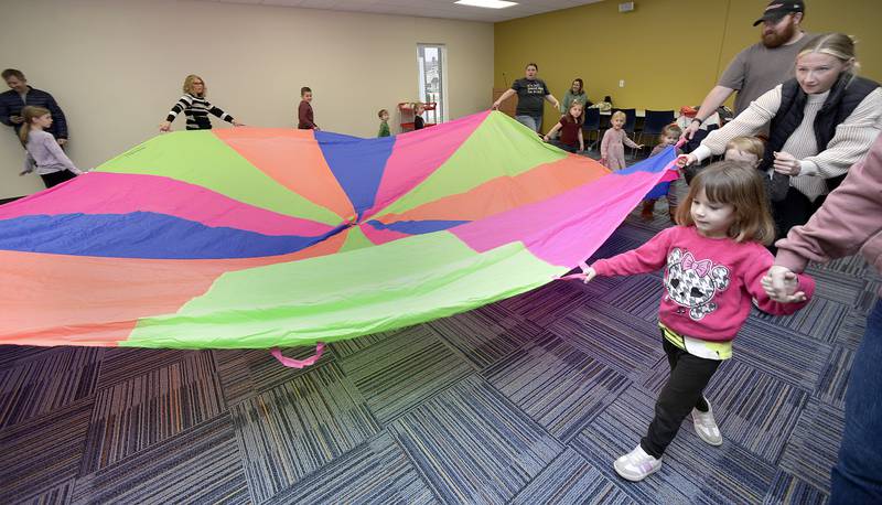 Children and parents enjoy themselves during Parachute Play at the Redidick Library in Ottawa Monday. Participants played games and sang songs while using a giant parachute.