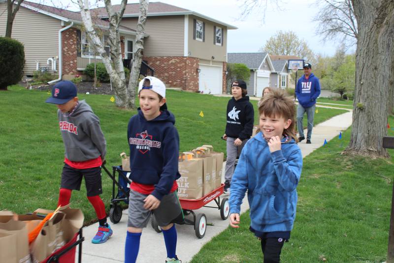 Algonquin kids in Leo Bonilla's neighborhood help him collect food donations their neighbors have given for the food drive.