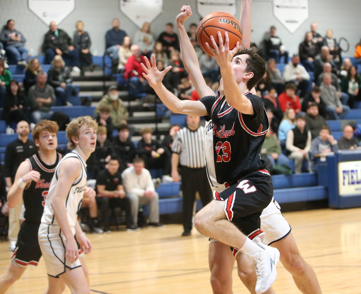 Woodland's Nick Plesko drives to the hoop around Fieldcrest's Brady Ruestman to score a basket on Tuesday, Dec. 19, 2023 at Fieldcrest High School.