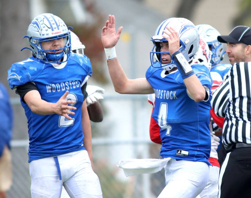 Woodstock’s Maximus Miller, left, congratulates Caden Thompson after a Thompson touchdown against Ottawa in varsity football at Larry Dale Field on the campus of Woodstock High School Saturday.