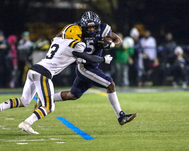 IC Catholic Prep's Aaron Harvey (5) runs away from St Laurence's Corey Taubr (3) during Class 4A third round playoff football game between St Laurence at IC Catholic Prep.  Nov 11, 2023.