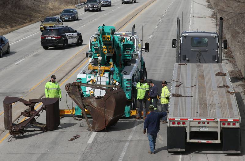 Crews with Senica Towing work the scene of a semi that struck the 7th Street bridge over Illinois Route 251 on Monday, March 10, 2025 in Peru. The semi was hauling two clamshell bucket for excavating equipment. The buckets struck the bridge and fell off of the flatbed onto Illinois Route 251.