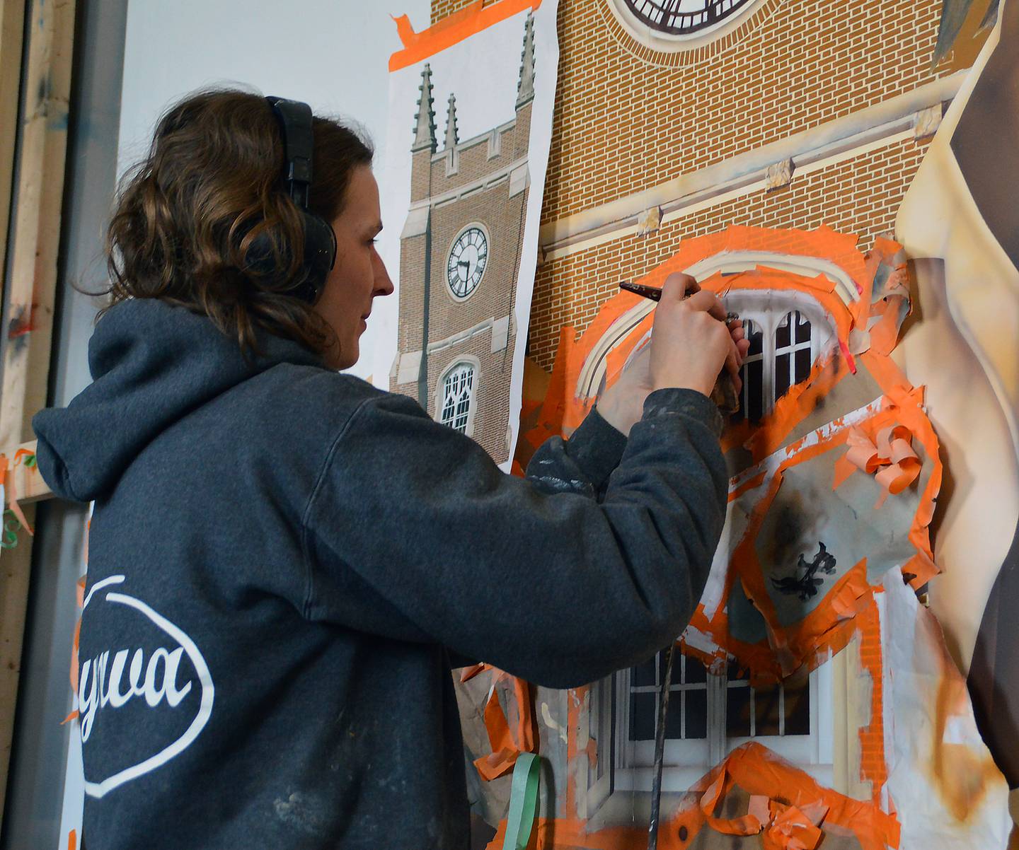 Artist Emily Maze touches up an iconic clock tower on an indoor mural commemorating Illinois Valley Community College’s 100 years. The community college was once housed at La Salle-Peru High School. The mural will be installed over the C-Building entrance.