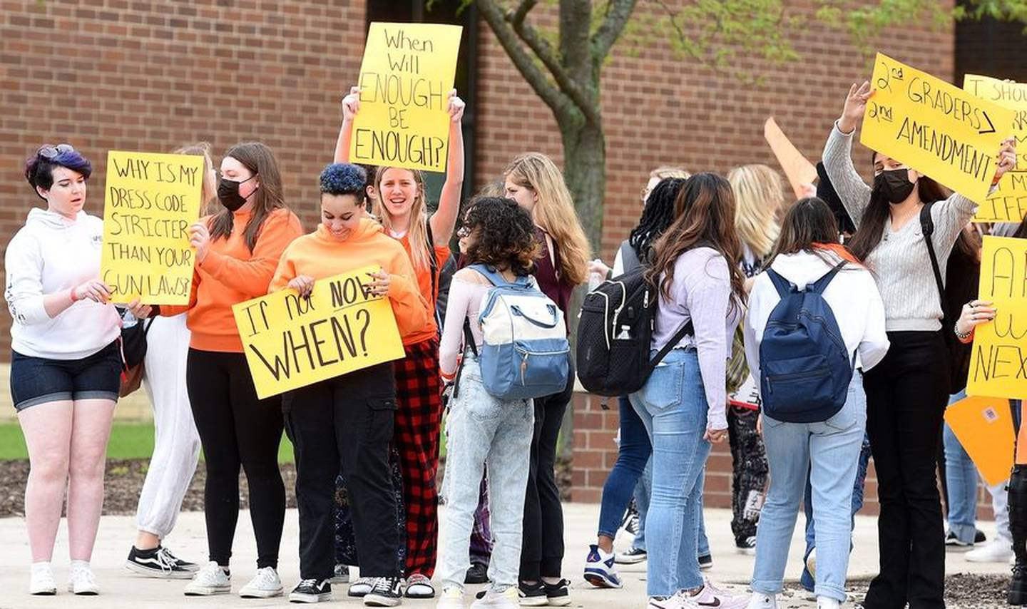 Students at South Elgin High School hold signs at the school Thursday after a walkout in protest of gun violence.