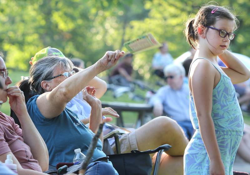 Grace Holtz, 8, from DeKalb, gets some help staying cool in the 90 degree heat from her grandma Cindy Bagby, from Paw Paw, who helps fan her Tuesday, June 21, 2022, during the DeKalb Municipal Band concert at Hopkins Park in DeKalb. The band presents concerts at 7:30 p.m. during the summer every Tuesday through August 23, with the exception of July 5.