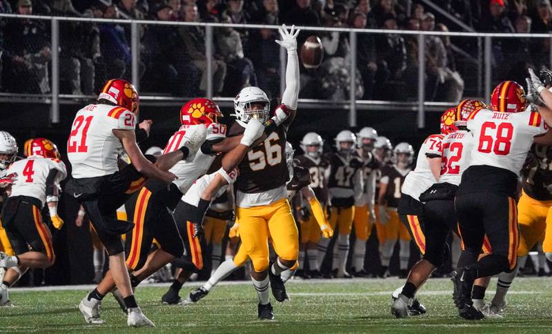 Batavia’s Ryan Boe (21) punts the ball over the arm of Mt. Carmel's Darion Williams (56) during a class 7A semifinal football playoff game at Mt. Carmel High School in Chicago on Saturday, Nov 18, 2023.