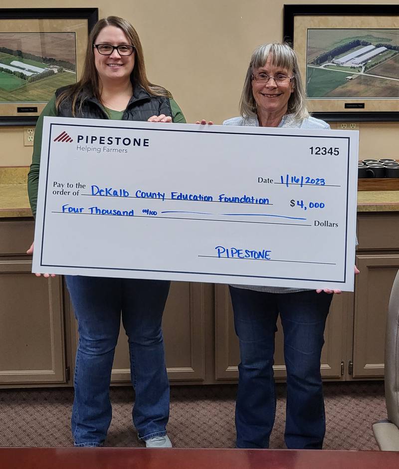 (Left to right); Pipestone Veterinary Services employee Cassie Felix donating a $400 check to Cindy Lofthouse of the DeKalb Education Foundation.