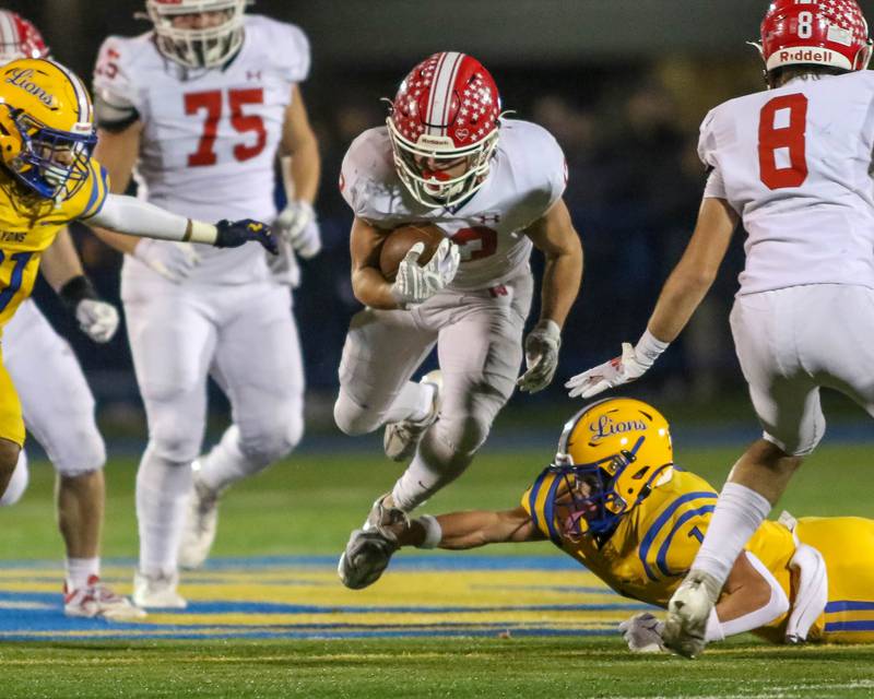 Naperville Central's Aiden Clark (13) is tripped up on a run during Class 8A quarterfinal football game between Naperville Central at Lyons on Friday, Nov 15, 2024  in Western Springs.