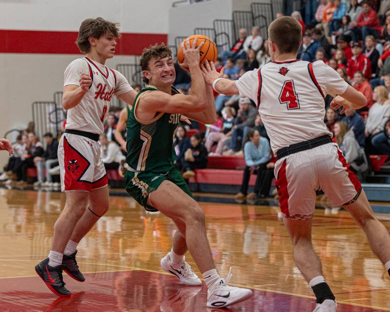 St. Bede's Gino Ferrari (4) euro-steps before leaping into layup whilst being guarded by Hall's Greyson Bickett (0) and Luke Bryant (4) on Saturday, January 31, 2026 at Hall High School in Spring Valley.