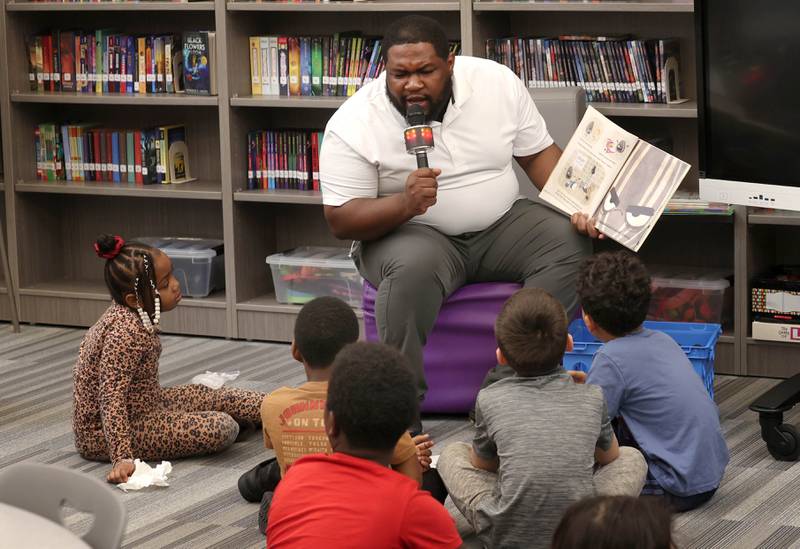 Mitchell Elementary School librarian Alontae McCain reads to first graders Thursday, March 19, 2026, in the library at the school in DeKalb.