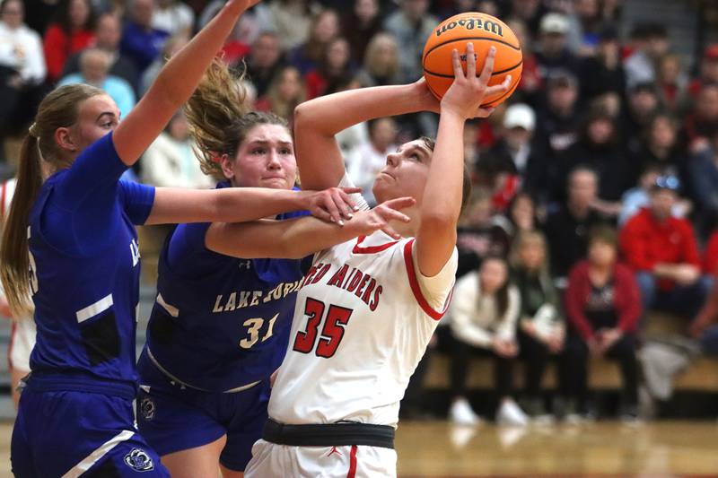 Huntley’s Paula Strzelecki, right, battles Lake Zurich’s Alex Nowak-Tice, center, and others in IHSA Class 4A Sectional girls basketball action on Tuesday, Feb. 25, 2025, at Huntley High School in Huntley.